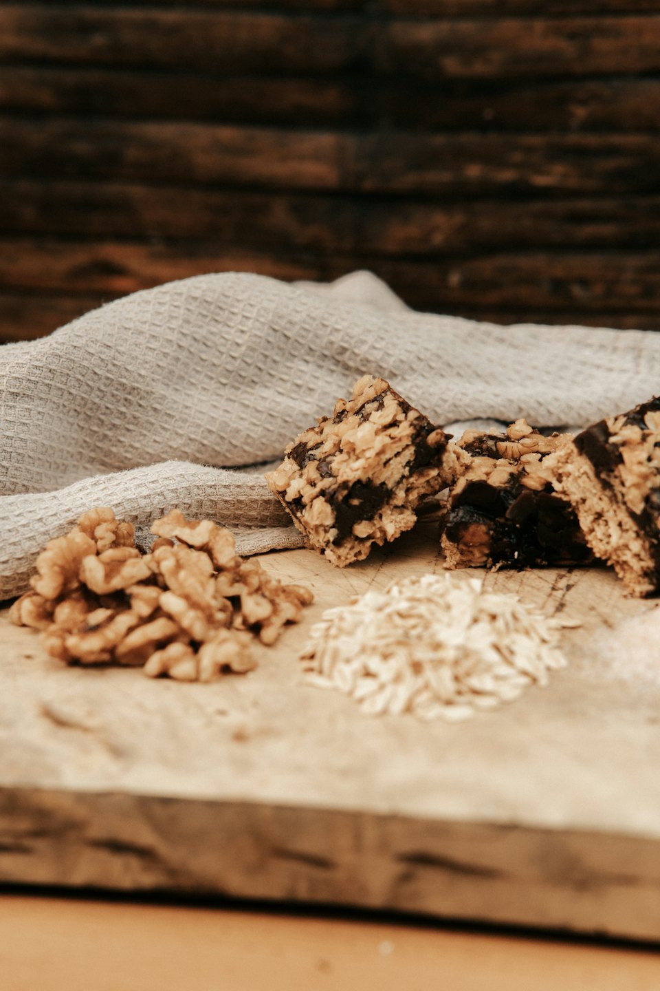 Homemade granola bars with walnuts and oats on a board.